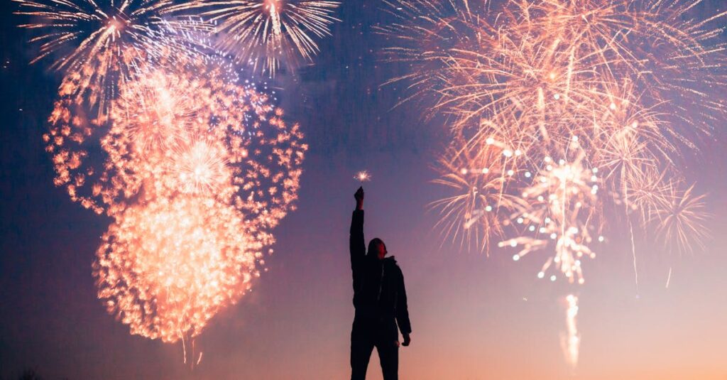A person celebrates under vibrant fireworks in the evening sky in Kragujevac, Serbia.