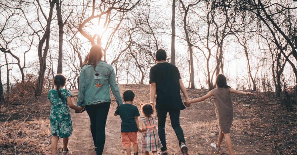 A family holding hands and walking along a bare path during a winter day, emphasizing unity and togetherness.