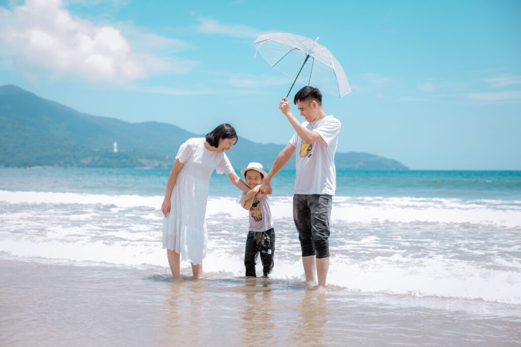 A joyful family enjoying a sunny day at Da Nang Beach, Vietnam, showcasing a heartwarming moment.