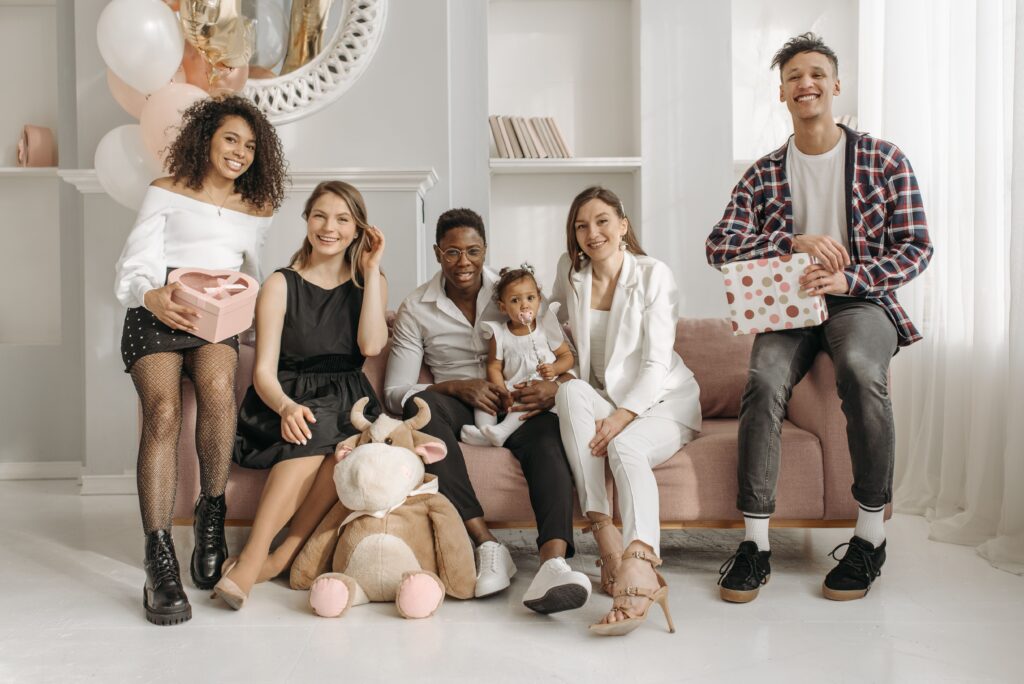 A happy family gathering indoors celebrating a birthday with smiles and gifts.